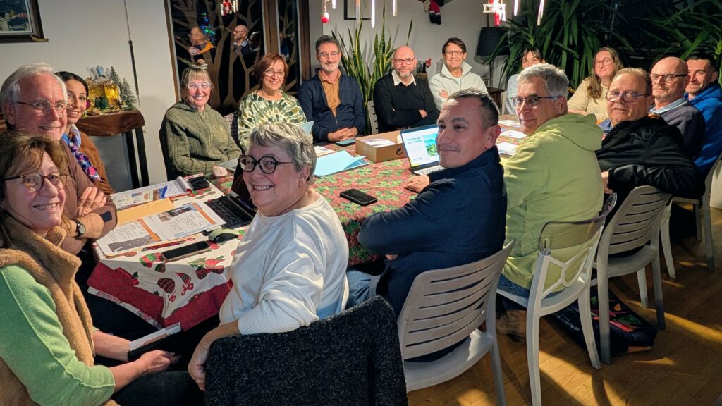 L'équipe Ensemble agir pour Tresserre 2026 avec Michel Thiriet autour d'une grande table en réunion de campagne.