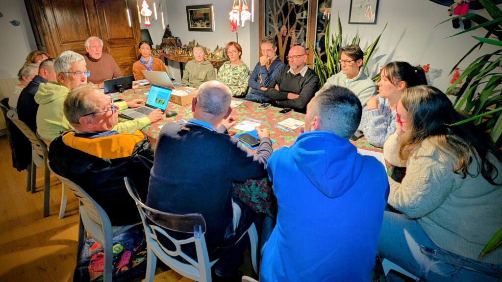 L'équipe Ensemble agir pour Tresserre 2026 avec Michel Thiriet autour d'une grande table en réunion de campagne