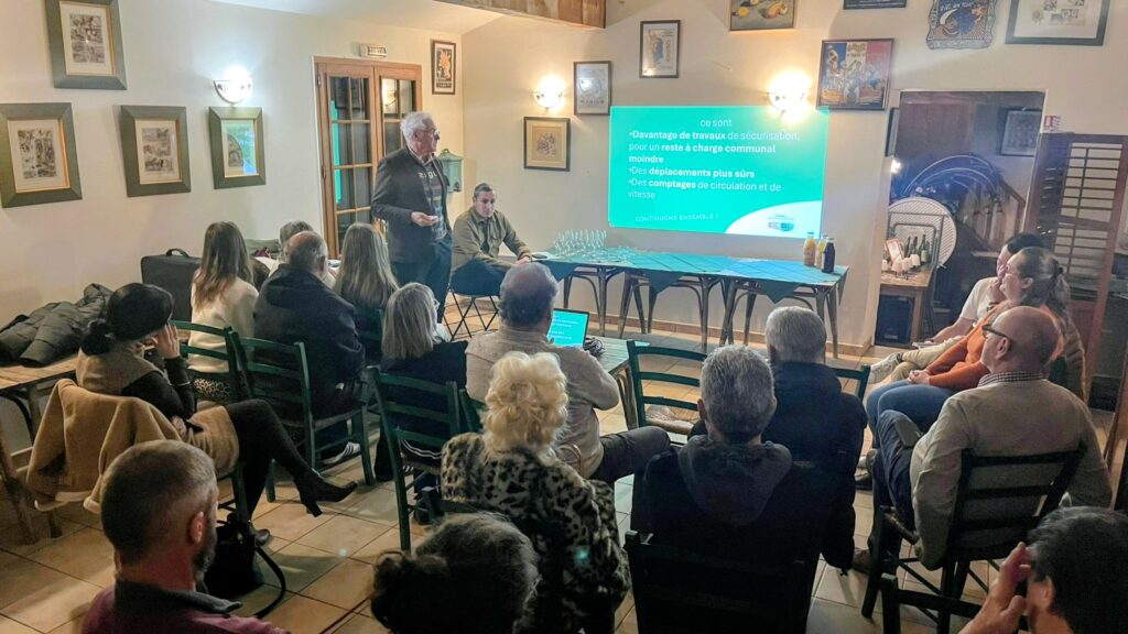 Des habitants du hameau de Nidolères à Tresserre et des membres de l'équipe Ensemble, agir pour Tresserre 2026 à l'Auberge de Nidolères devant un diaporama projeté au mur.